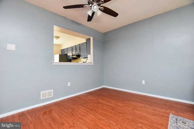 unfurnished room with visible vents, baseboards, and wood finished floors