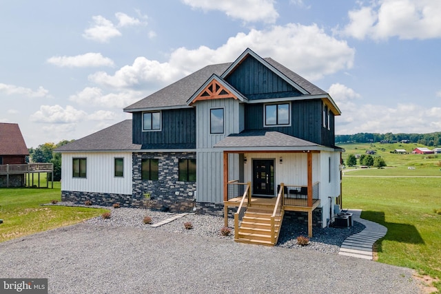 view of front of property with covered porch, a shingled roof, board and batten siding, and a front yard