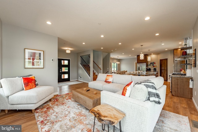 living area with light wood-style floors, stairs, and recessed lighting