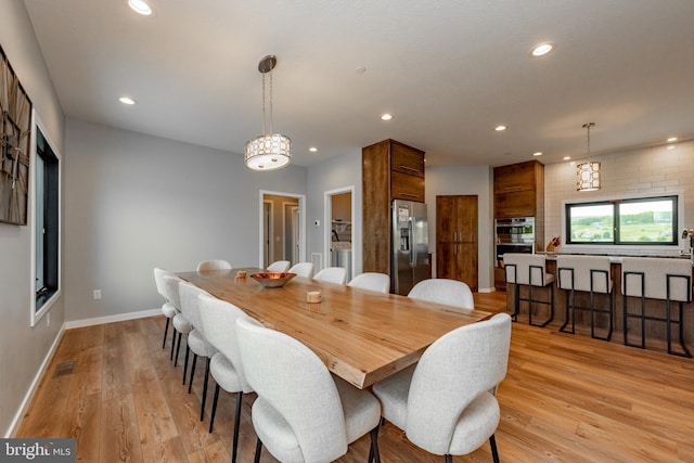 dining space with recessed lighting, visible vents, light wood-style flooring, washer and dryer, and baseboards