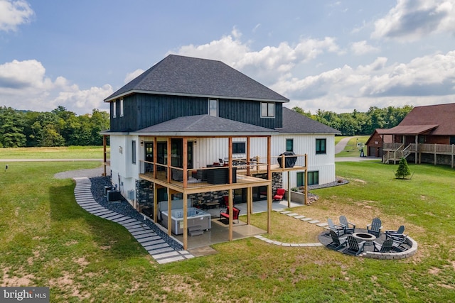 back of property featuring a patio, an outdoor fire pit, a lawn, and roof with shingles