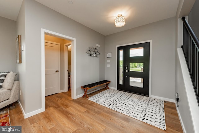 foyer featuring light wood-style flooring and baseboards