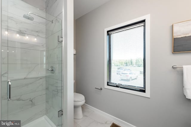 bathroom featuring toilet, marble finish floor, a marble finish shower, and baseboards