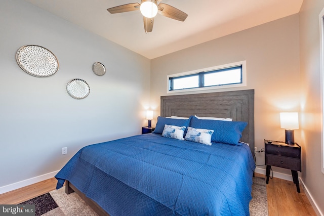 bedroom with lofted ceiling, wood finished floors, a ceiling fan, and baseboards