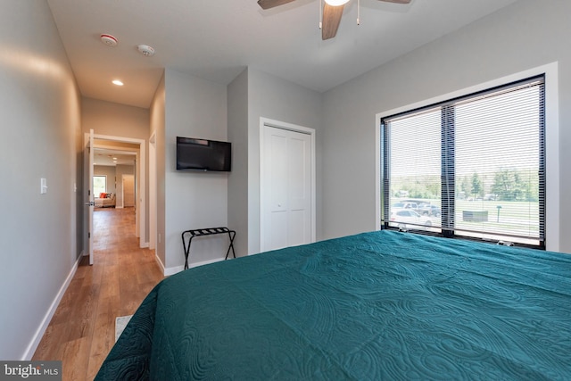 unfurnished bedroom with recessed lighting, wood finished floors, a ceiling fan, baseboards, and a closet