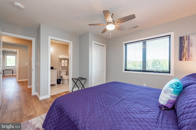 bedroom featuring multiple windows, visible vents, baseboards, and wood finished floors