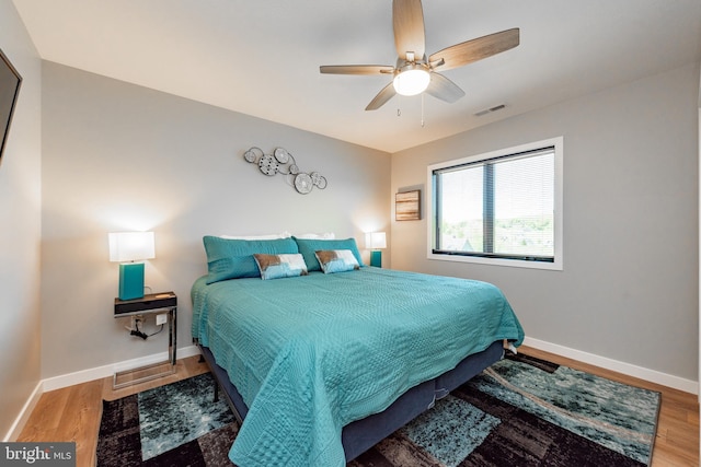 bedroom featuring wood finished floors, visible vents, and baseboards