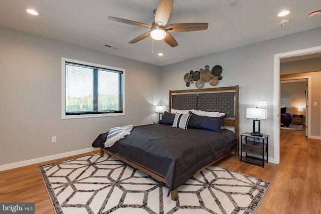 bedroom with baseboards, visible vents, wood finished floors, and recessed lighting