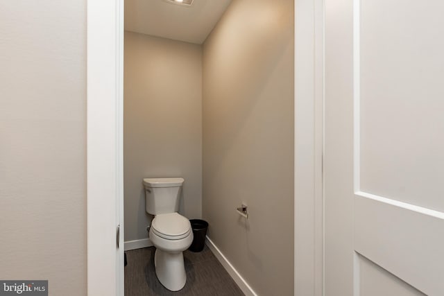 bathroom featuring toilet and baseboards