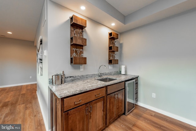 kitchen featuring open shelves, wine cooler, a sink, and light wood-style floors