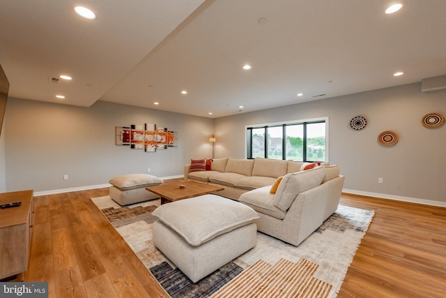 living area with recessed lighting, light wood-style flooring, and baseboards