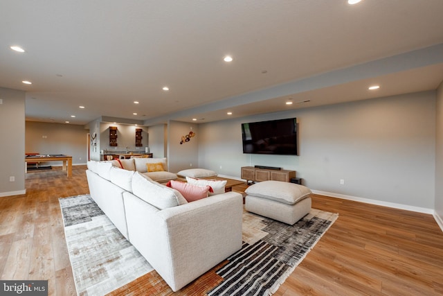 living room with recessed lighting, baseboards, and light wood finished floors