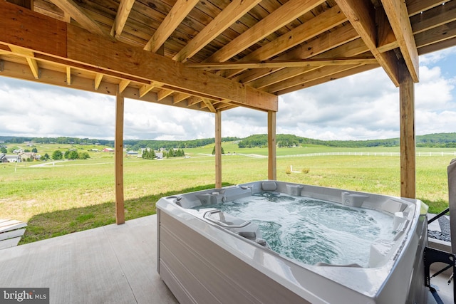 view of patio with a rural view and a hot tub