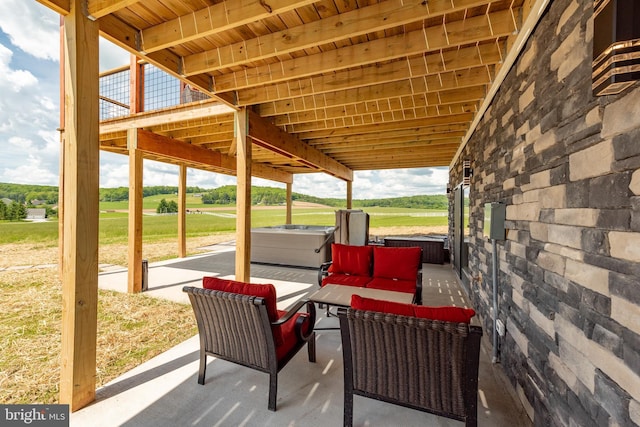 view of patio / terrace with a hot tub and an outdoor hangout area