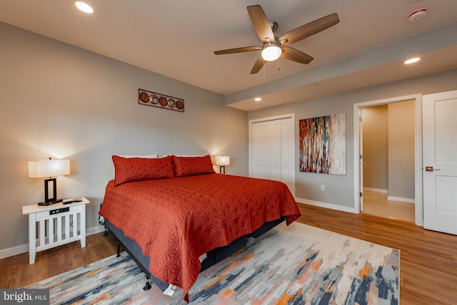 bedroom with baseboards, wood finished floors, and recessed lighting