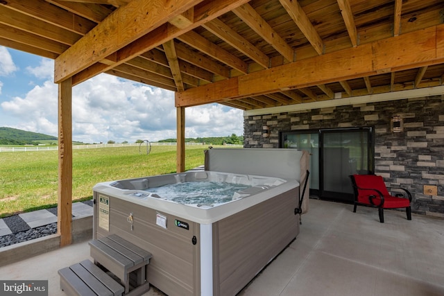 view of patio / terrace featuring a rural view and a hot tub