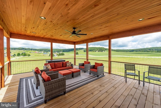 wooden terrace with a rural view, an outdoor living space, and a ceiling fan