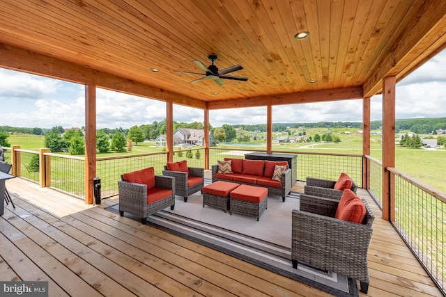 wooden terrace with ceiling fan, a yard, and an outdoor hangout area