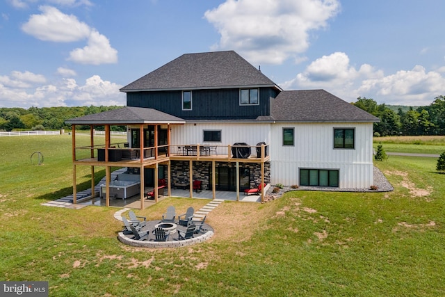 back of property featuring a lawn, an outdoor fire pit, a patio area, a wooden deck, and stairs