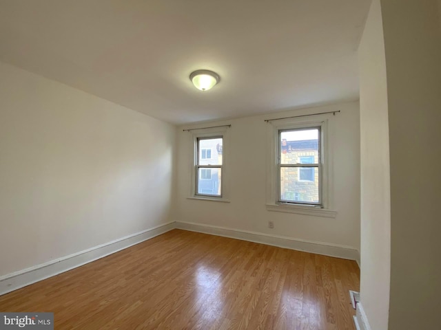 unfurnished room with light wood finished floors and baseboards