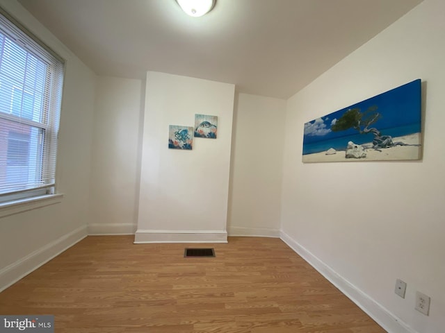 unfurnished room with visible vents, light wood-style flooring, and baseboards