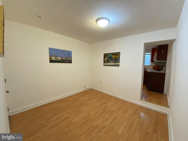 spare room with light wood-style floors and baseboards