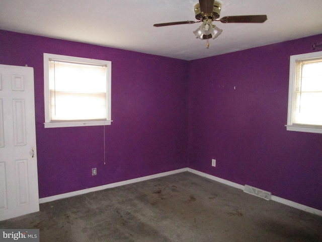 empty room featuring carpet floors, a ceiling fan, visible vents, and baseboards