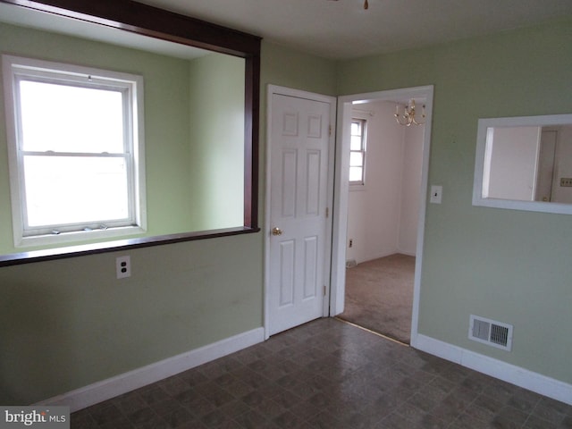 unfurnished room featuring baseboards and visible vents