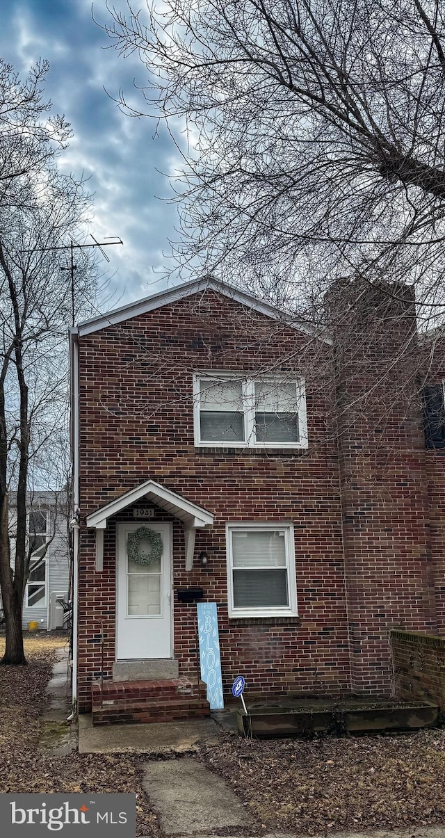 traditional home featuring entry steps and brick siding