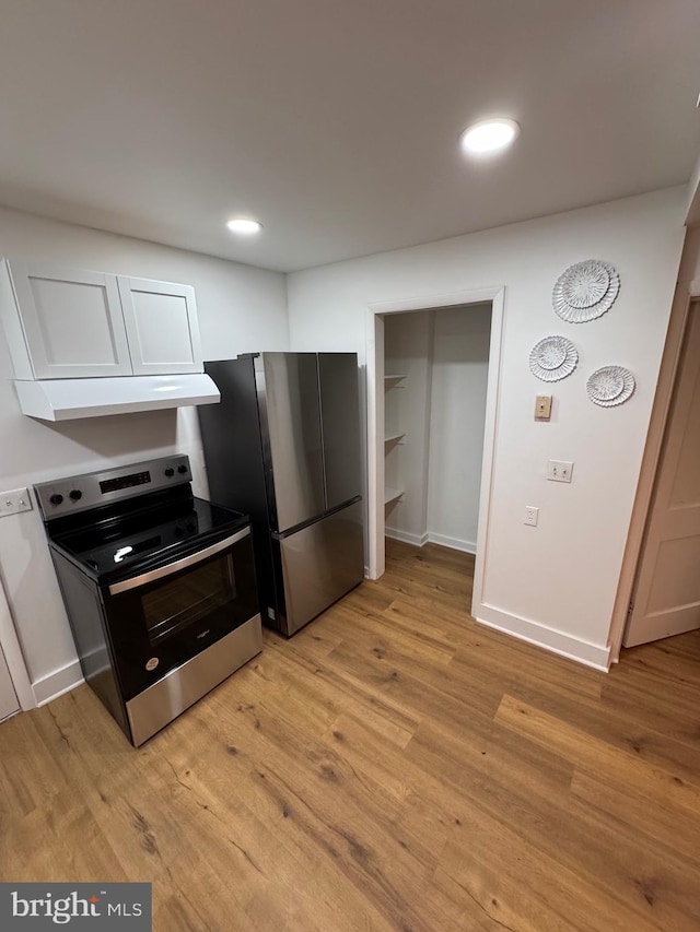 kitchen featuring light wood finished floors, baseboards, appliances with stainless steel finishes, and recessed lighting