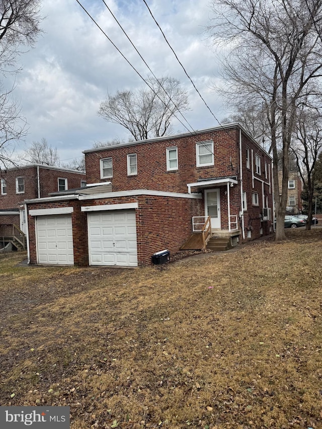 view of front facade with a garage, driveway, and brick siding