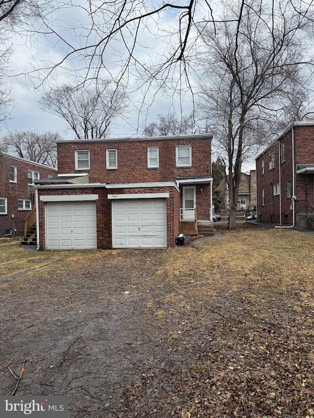 view of front of property featuring a garage, brick siding, and driveway