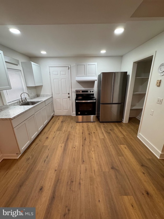 kitchen featuring appliances with stainless steel finishes, recessed lighting, a sink, and light wood-style floors