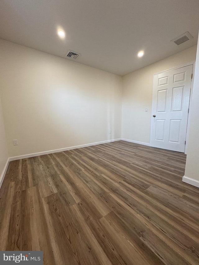 unfurnished room with dark wood-style floors, recessed lighting, visible vents, and baseboards