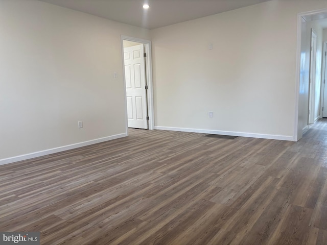 empty room with recessed lighting, wood finished floors, and baseboards