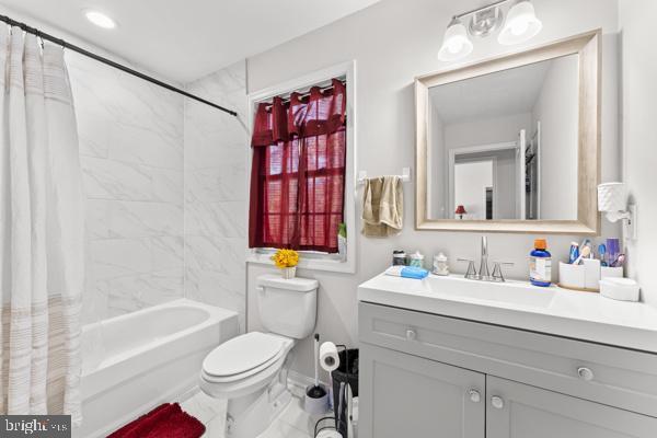 bathroom with shower / bath combination with curtain, marble finish floor, vanity, and toilet