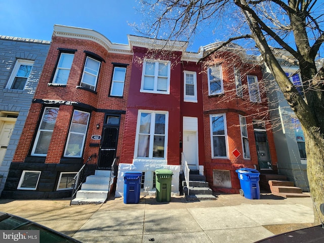 townhome / multi-family property featuring entry steps and brick siding