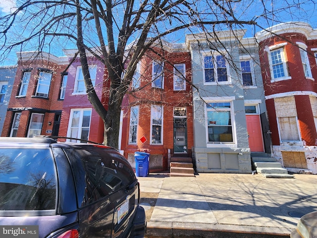 townhome / multi-family property with entry steps and brick siding