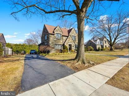 view of side of property with stone siding and a yard