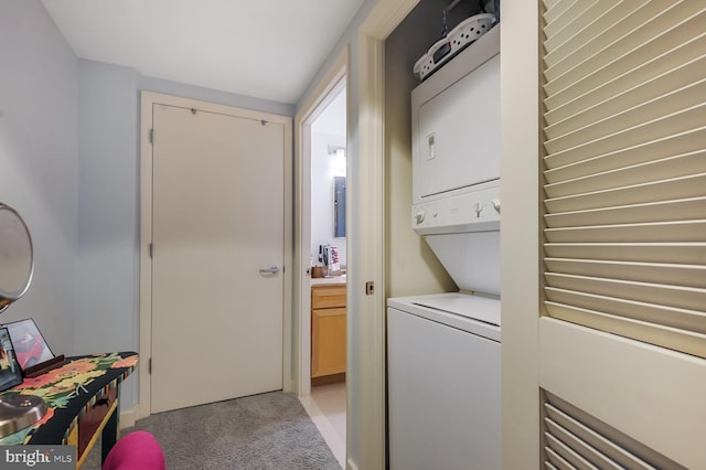 washroom with stacked washing maching and dryer, laundry area, and light colored carpet