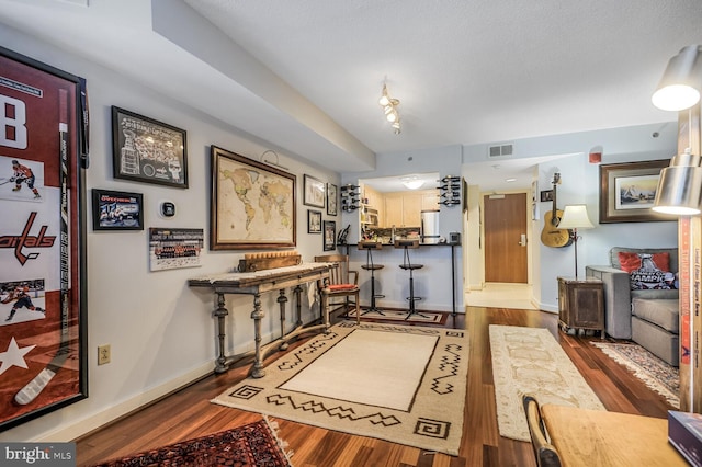 interior space featuring baseboards, visible vents, and wood finished floors