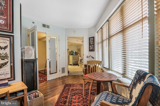 interior space featuring dark wood-style floors, a textured ceiling, and visible vents