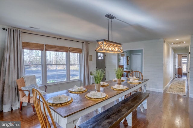 dining room with visible vents, baseboards, and hardwood / wood-style flooring