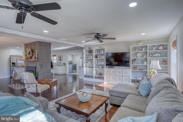 living room with a brick fireplace, recessed lighting, and dark wood-style flooring