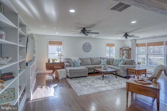 living room with a wealth of natural light, recessed lighting, visible vents, and dark wood-style flooring