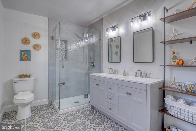 bathroom with double vanity, toilet, a stall shower, and a sink