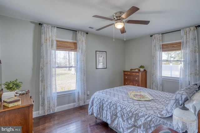 bedroom with visible vents, ceiling fan, baseboards, and hardwood / wood-style floors