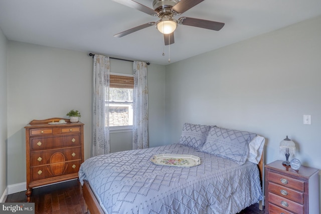 bedroom with a ceiling fan, baseboards, and wood finished floors