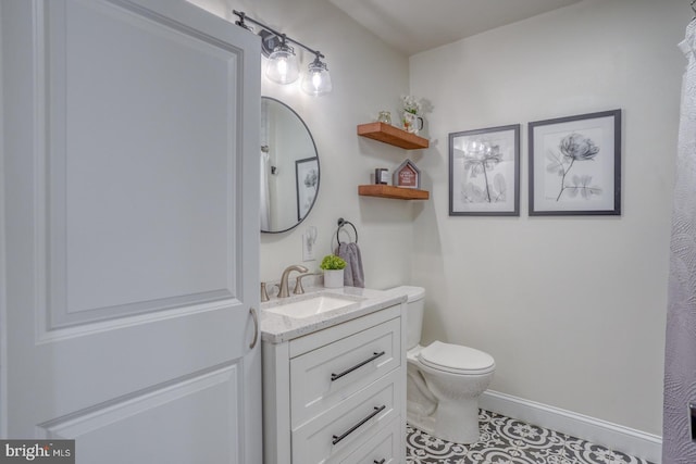 bathroom featuring vanity, toilet, and baseboards