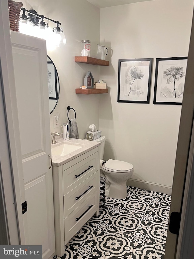 bathroom with tile patterned floors, toilet, vanity, and baseboards